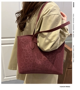 Detail of dark red leopard print tote bag featuring matte leather and slim shoulder strap