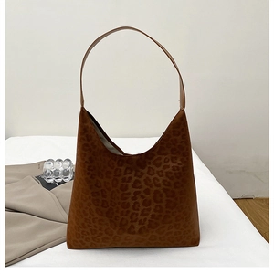 Gros plan détaillé d'un sac hobo léopard en daim marron avec un design triangulaire épuré