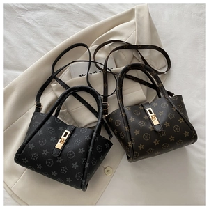 Detailed view of mini tote bags with flower patterns and golden rectangular metal locks