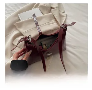 Vue intérieure du sac à bandoulière en cuir bordeaux brillant montrant sa grande capacité