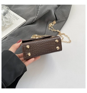 Detail view of the brown croc-embossed bag base with protective gold metal feet