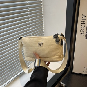Fashionable cream nylon crossbody bag with cute bear logo and adjustable wide shoulder strap
