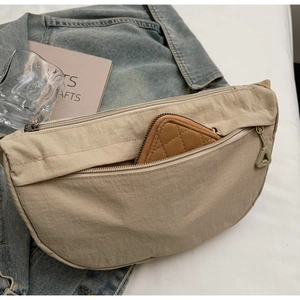 Dettaglio della borsa a mezzaluna in nylon beige con tasche e portacarte all'interno