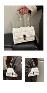 Détail du sac carré blanc matelassé avec bandoulière chaîne et fermoir argenté