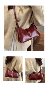 Détail du sac sous l'aisselle en cuir bordeaux brillant avec boucle à œillet argenté