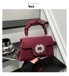 Detailed macro view of the wine red velvet handbag with crystal buckle and ruched handle