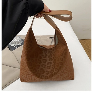 Détail d'un sac hobo à imprimé léopard marron avec une large bandoulière élégante