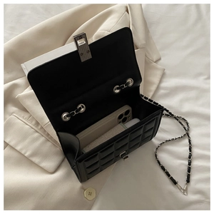 Vue détaillée de l'intérieur d'un sac à bandoulière noir matelassé avec chaîne en argent
