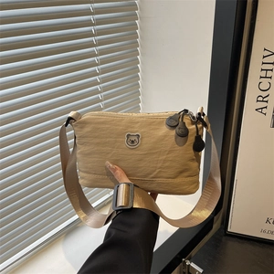 Fashionable khaki nylon crossbody bag with cute bear emblem and adjustable wide strap