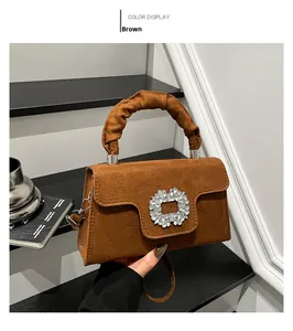 Close-up of brown suede handbag featuring ruched handle and crystal buckle detail