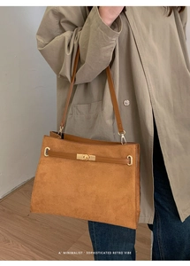 Detail der karamellbraunen Wildleder-Tote mit Lederriemen und goldenem Drehverschluss