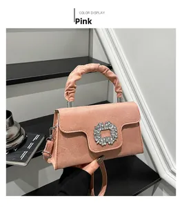 Detail of pink suede handbag with crystal buckle and ruched cloud handle