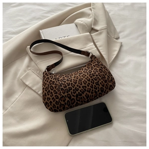 Leopard print hobo bag on beige blazer with artistic books showing textured material