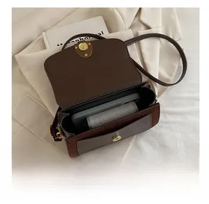 Internal capacity of brown leather crossbody bag showing space for phone and wallet