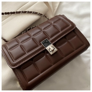 Détail du sac à rabat matelassé marron foncé en similicuir avec bandoulière chaîne