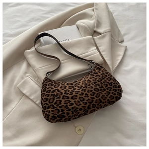 Macro view of leopard print faux suede baguette bag with silver zipper and slim strap