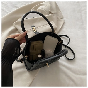 Detailed interior of a grey monogram tote bag showing large capacity with daily items