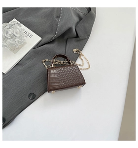 Detailed view of the dark brown crocodile pattern mini handbag with golden chain strap