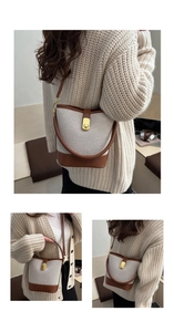 Detail of canvas bucket bag with brown leather trim and golden metal turn-lock closure