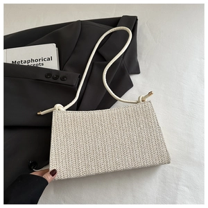 Close-up of beige woven texture and knot detail on minimalist rectangular shoulder bag