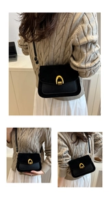 Three-way view of a black retro suede saddle bag with gold horseshoe buckle and strap