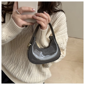 Detail of grey patent leather mini half-moon bag with metallic zipper and glossy finish