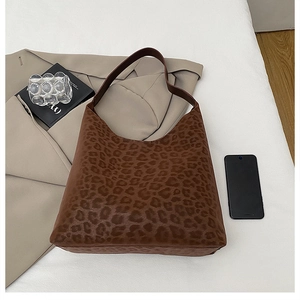 Detail view of large brown leopard print tote bag with shoulder strap in a stylish setup