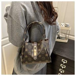 Detail view of large capacity tote bag with vintage floral pattern and gold metal clasp