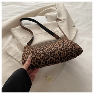 Detail of leopard print underarm bag featuring suede texture and faux leather strap