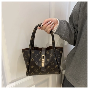 Close-up of star and floral printed brown handbag with a gold-tone metallic buckle clasp