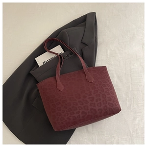 Macro shot of dark burgundy leopard print tote bag with soft texture and long strap
