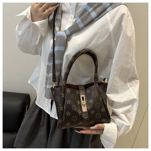 Close-up of vintage star pattern faux leather and gold metal lock on brown tote bag