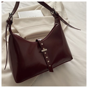 Détail macro du sac hobo bordeaux brillant avec rivets argentés et boucle en métal