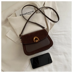 Detail view of retro brown crossbody bag with matte gold U-buckle and premium suede texture