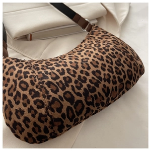Close-up of leopard print hobo bag texture with brown leather strap and silver ring