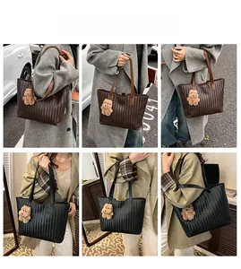 Detail of woven leather tote bag texture with cute teddy bear charm on the handle