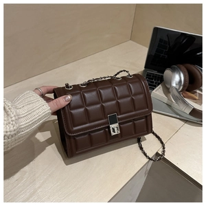 Détail du sac matelassé marron chocolat en similicuir avec fermoir rotatif argenté