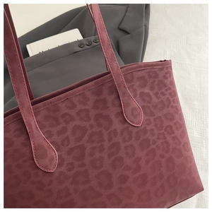Close-up of deep red leopard print tote bag with premium faux suede texture