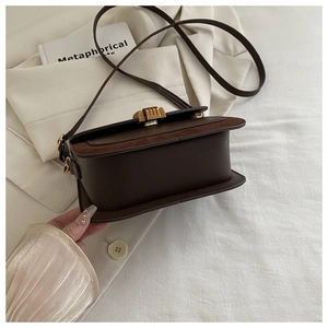 Detail of vintage brown crossbody bag with flap turn-lock and suede leather patchwork