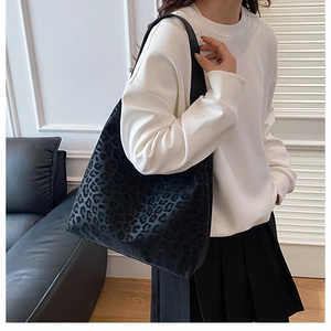 Detail of large capacity tote bag with black leopard print and soft velvet texture