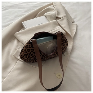 Detail of leopard print underarm bag interior showing wallet and cosmetics storage