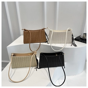 Trio of woven shoulder bags in neutral colors with stylish side tassels on a white display