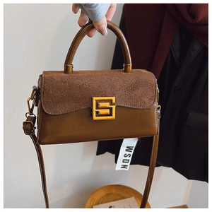 Detailed close-up of dark brown matte and smooth leather textures with gold geometric buckle