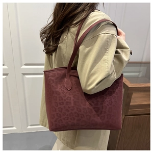 Detail view of large burgundy leopard print tote bag in matte suede fabric with long strap