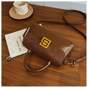 Detail of vintage brown textured crossbody bag with metal buckle on a dark wood table