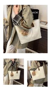 Detail of cream woven tote bag with brown leather straps and cute plush bear charm