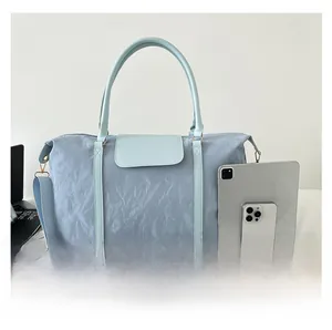 Macro detail showing large travel bag capacity with tablets and soft nylon texture