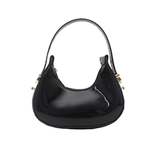 Polished black patent leather crescent hobo bag with gold hardware and top handle