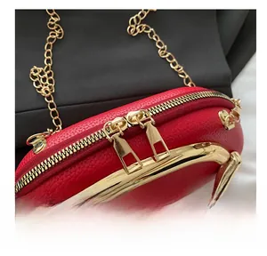 Close-up of red lychee grain leather crossbody bag with light gold double metal zippers