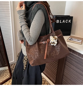 Close-up of leopard print tote bag featuring a cute character plush charm and PU leather detail